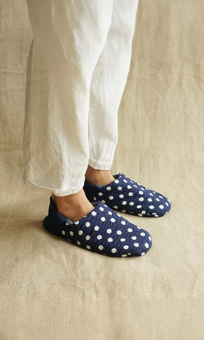 Plümo  Person in white pants wears Dotted Slippers with white polka dots on beige fabric; made in Japan.