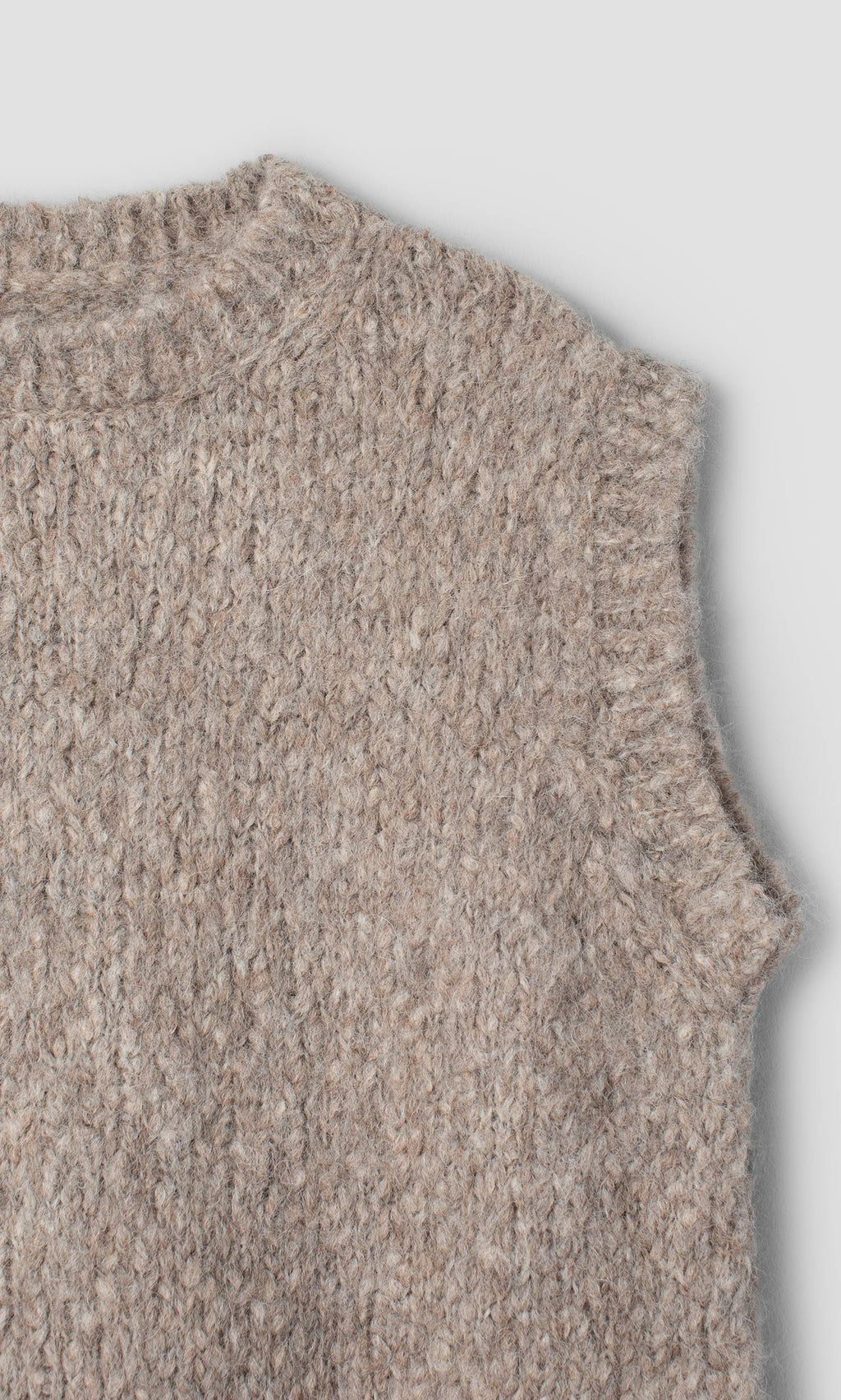 Plümo  Borwick Tunic: a sleeveless, beige, Swedish cable-knit sweater vest with a crew neckline.