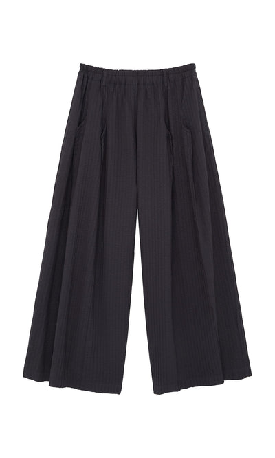 Plümo- Kiri Pintuck Pants: Black wide-leg pants with vertical pleats and an elastic waistband, inspired by Japanese style.