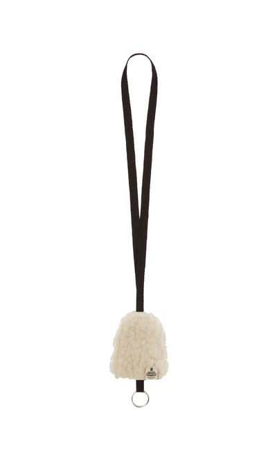 Plümo- The Shearling Keyholder is a black lanyard with a fluffy white wool pouch and metal keyring at the bottom.
