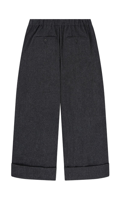 Plümo- Horton Pants in dark gray Italian wool, wide-leg with cuffed hems and two back pockets, shown flat on white.