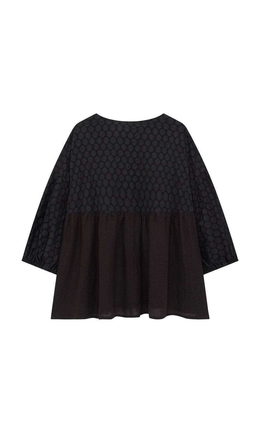Plümo- The Tuppence Blouse is a loose black top with textured polka dots above a plain lower half, shown on white.