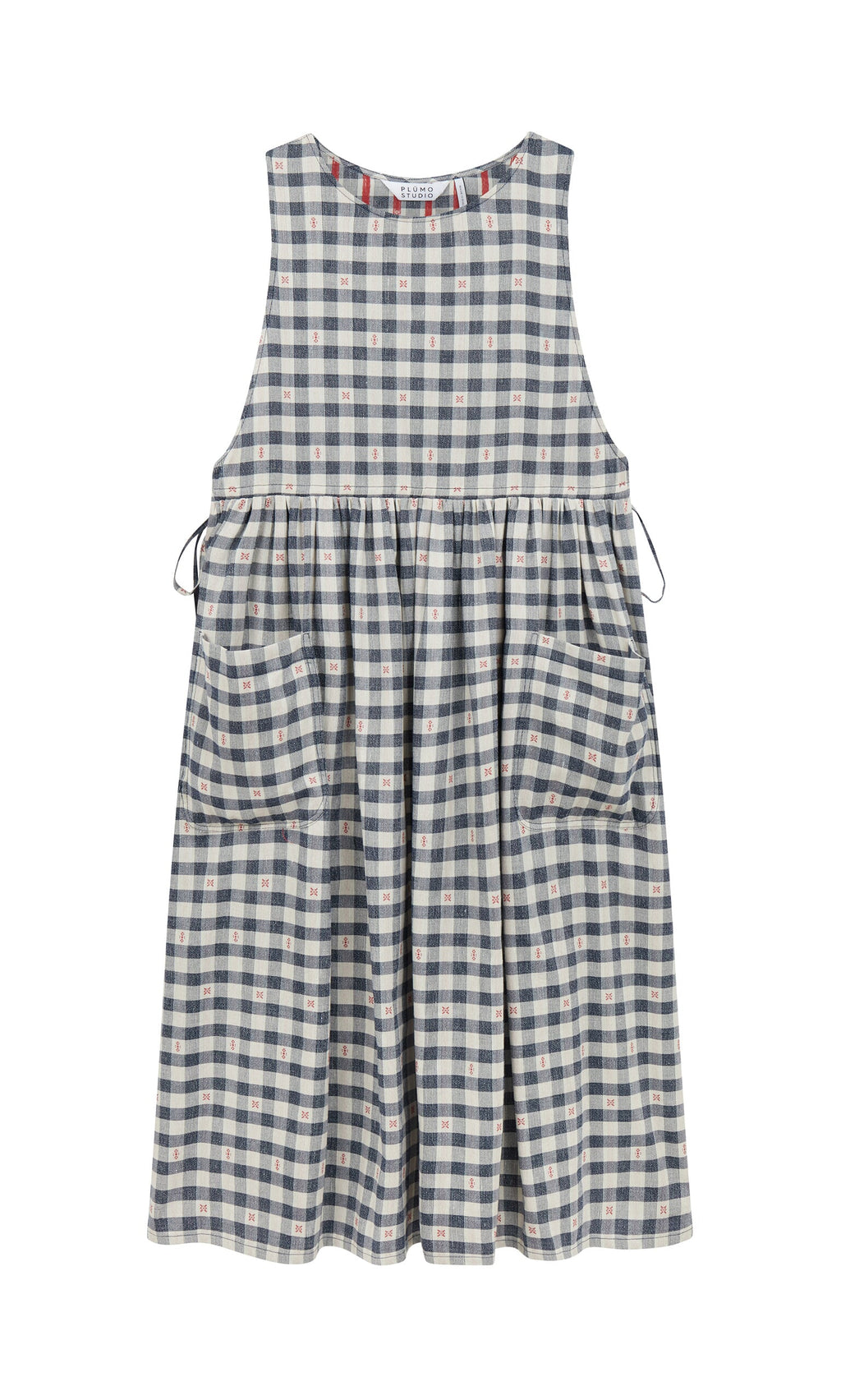 Plümo- The OMalley Apron Dress features a sleeveless blue and white gingham, large pockets, and adjustable side ties.