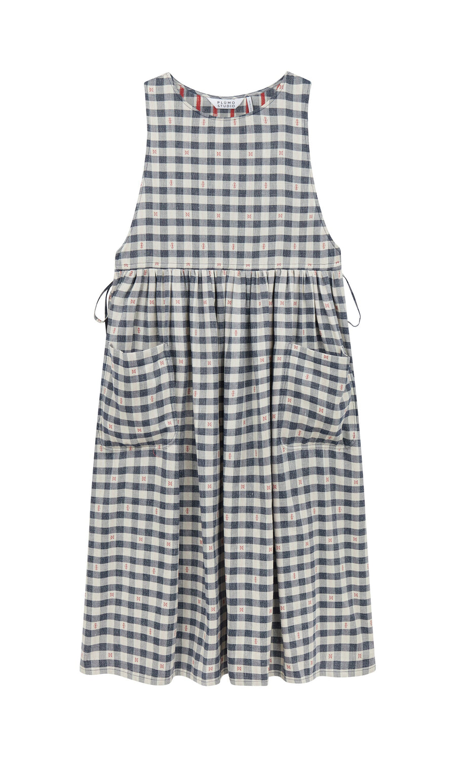 Plümo- The OMalley Apron Dress features a sleeveless blue and white gingham, large pockets, and adjustable side ties.