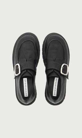 Plümo  A pair of black leather shoes with silver buckles displayed from above on a white background.