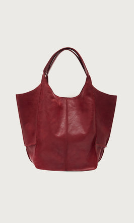 Plümo  Large, deep red leather tote bag with two handles, displayed against a plain white background.