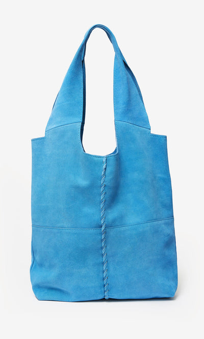Plümo- The Alves Bag is a bright blue suede bag with a single shoulder strap and bold whip stitch seams down the center.