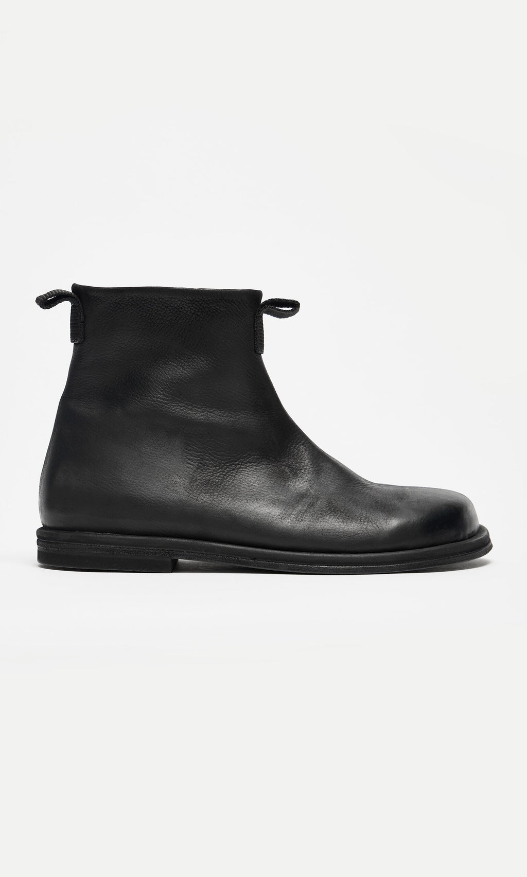 Plümo- Ancona Boots: Black waxy leather ankle boots with round toe, flat sole, and pull tabs, Danish-inspired design.