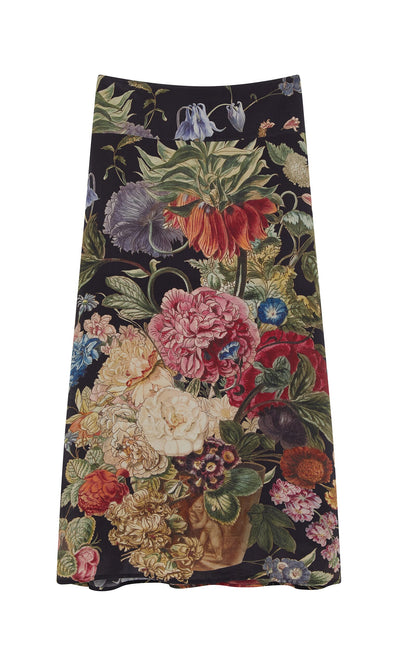 Plümo- The Auricula Skirt is a long black A-line skirt with a colorful botanical print featuring various flowers.