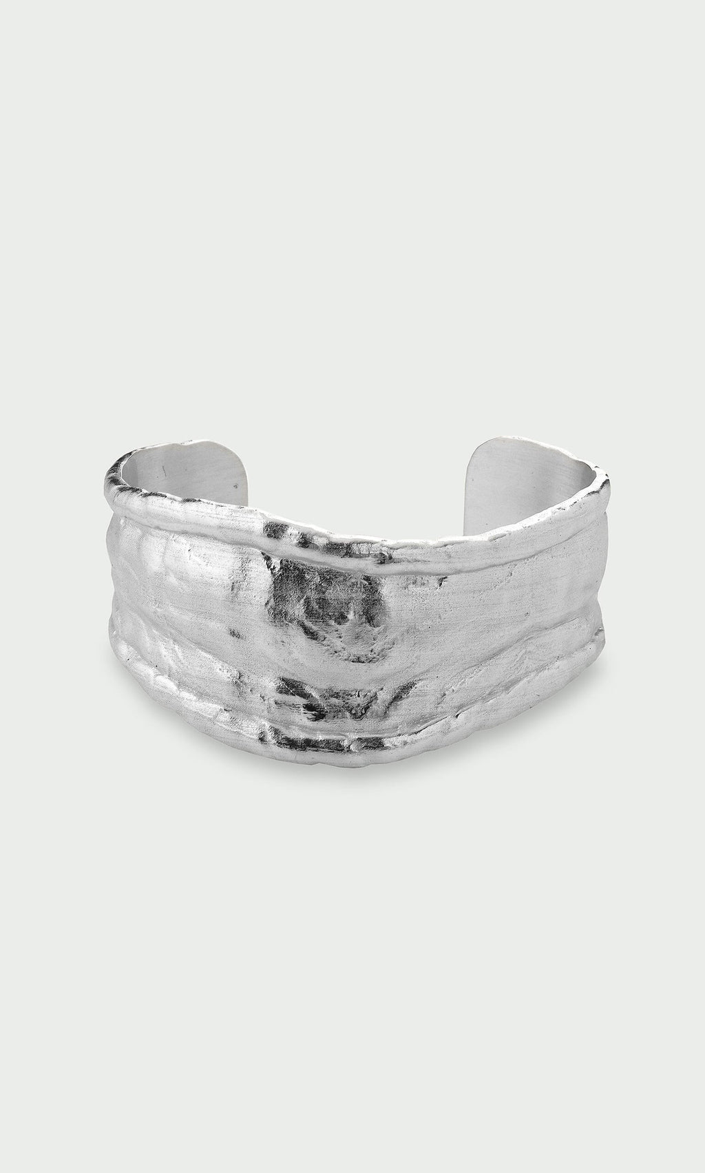 Plümo- Bastion Bangle: Wide, textured, organically shaped recycled silver bangle, shown on a light grey background.