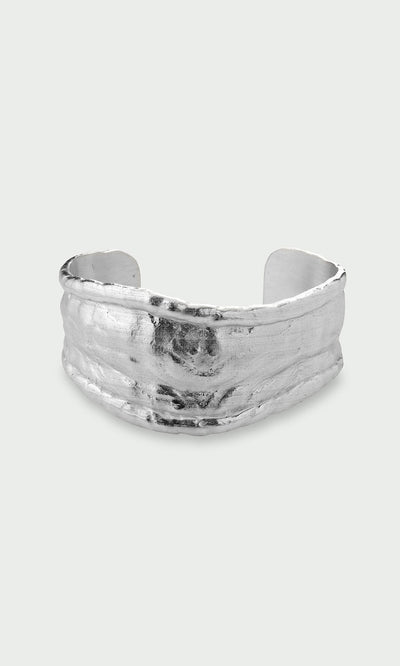 Plümo- Bastion Bangle: Wide, textured, organically shaped recycled silver bangle, shown on a light grey background.