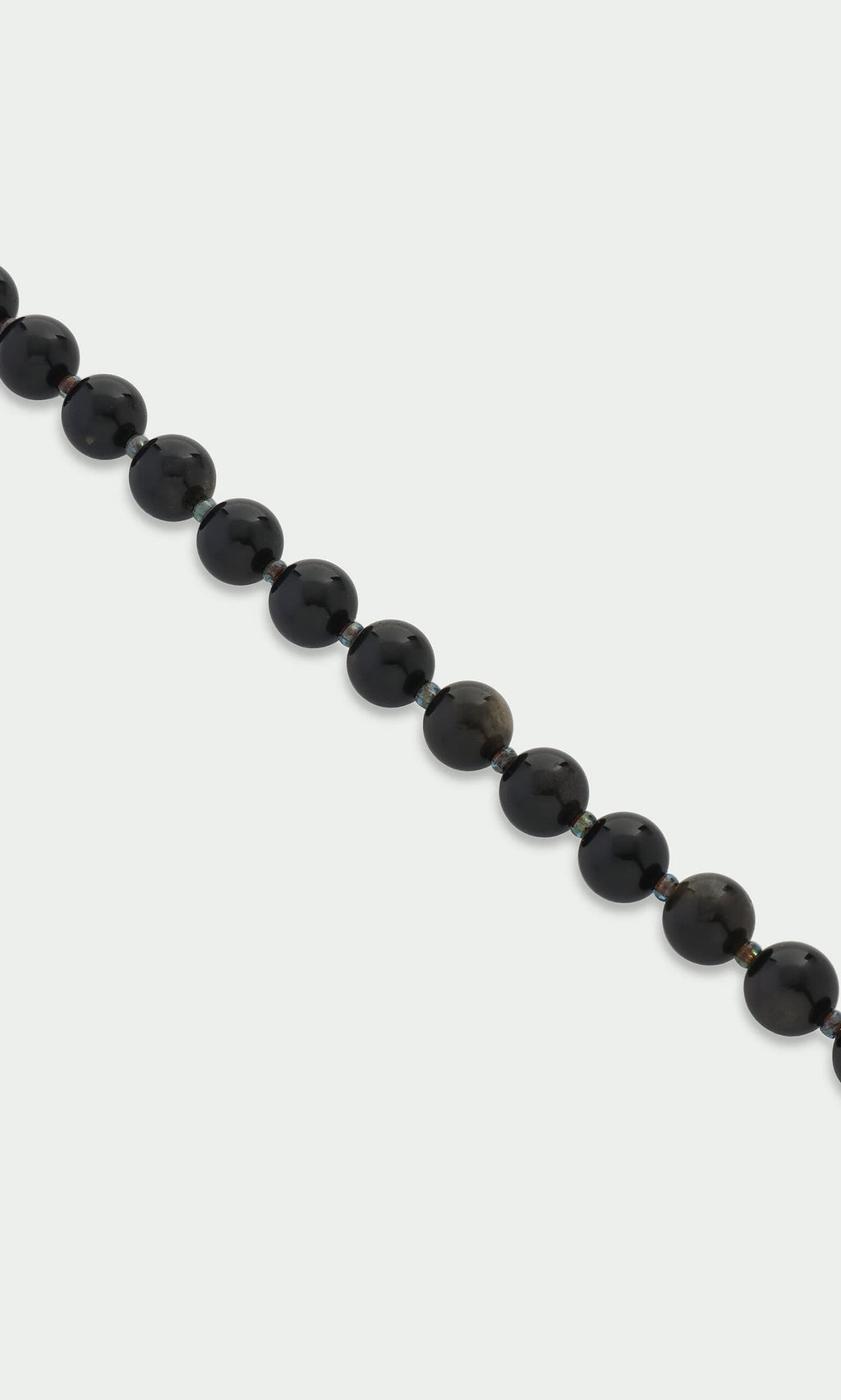Plümo- A strand of glossy black beads—Obsidian Bracelet—set against a plain white background.