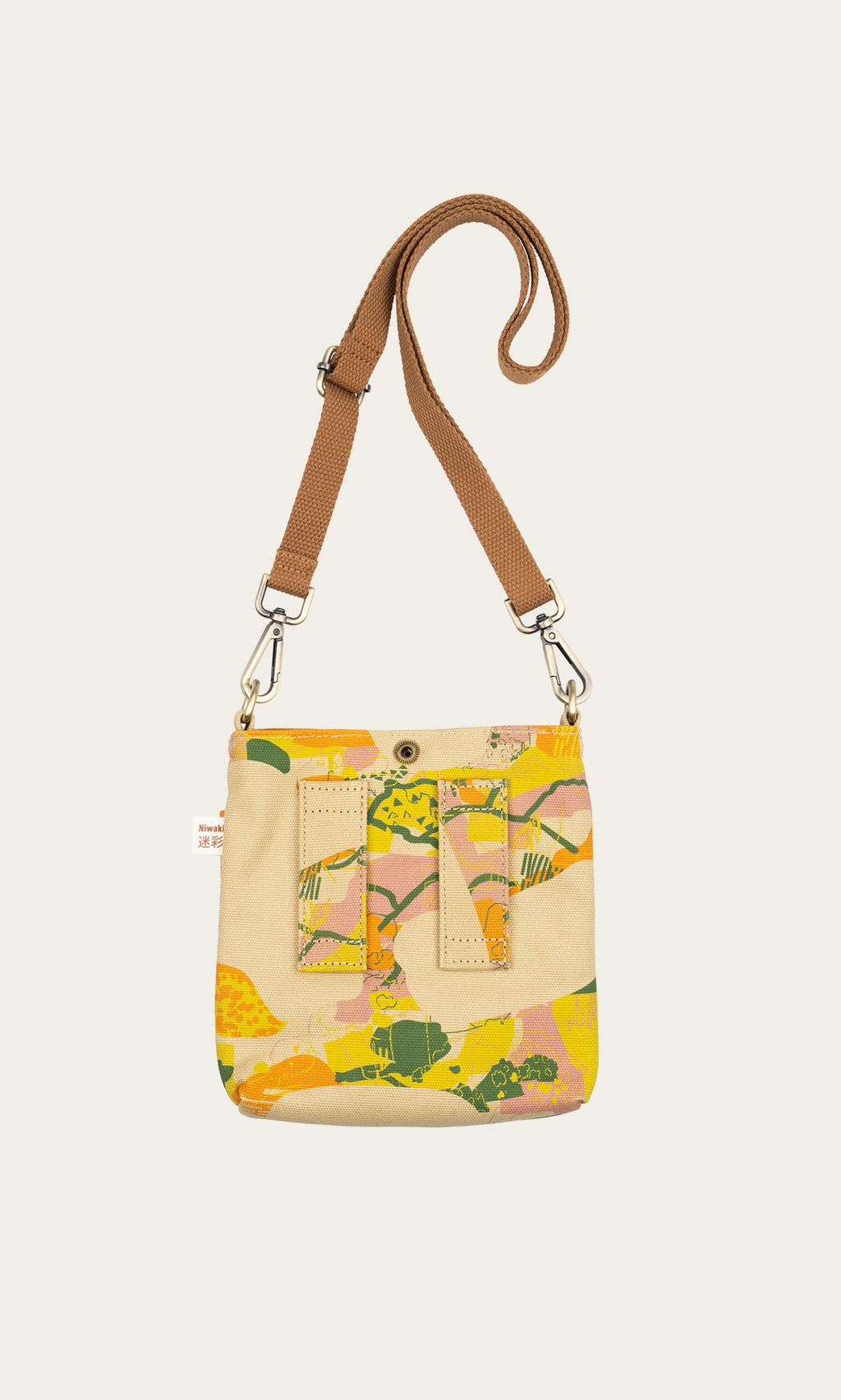 Plümo- The Camo Pouch Bag is a small weatherproof canvas shoulder bag with a brown strap and an abstract, colorful front.