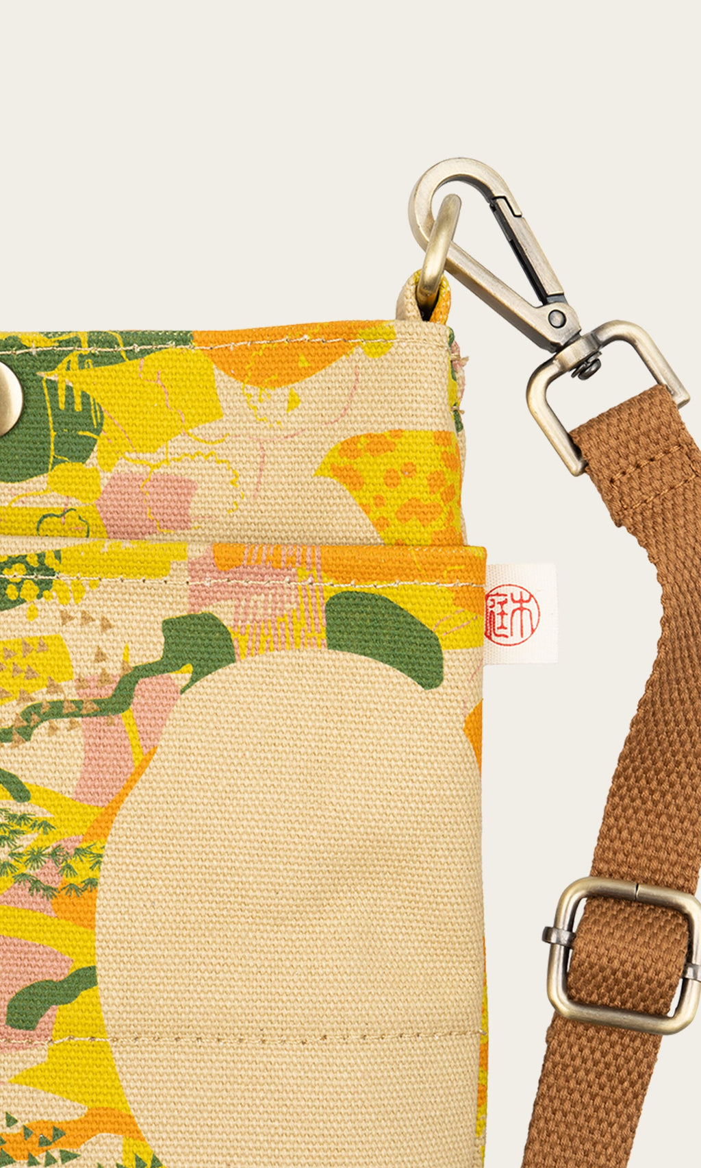 Plümo- Close-up of the Camo Pouch Bag featuring abstract patterns and a brown adjustable strap with a metal clasp.