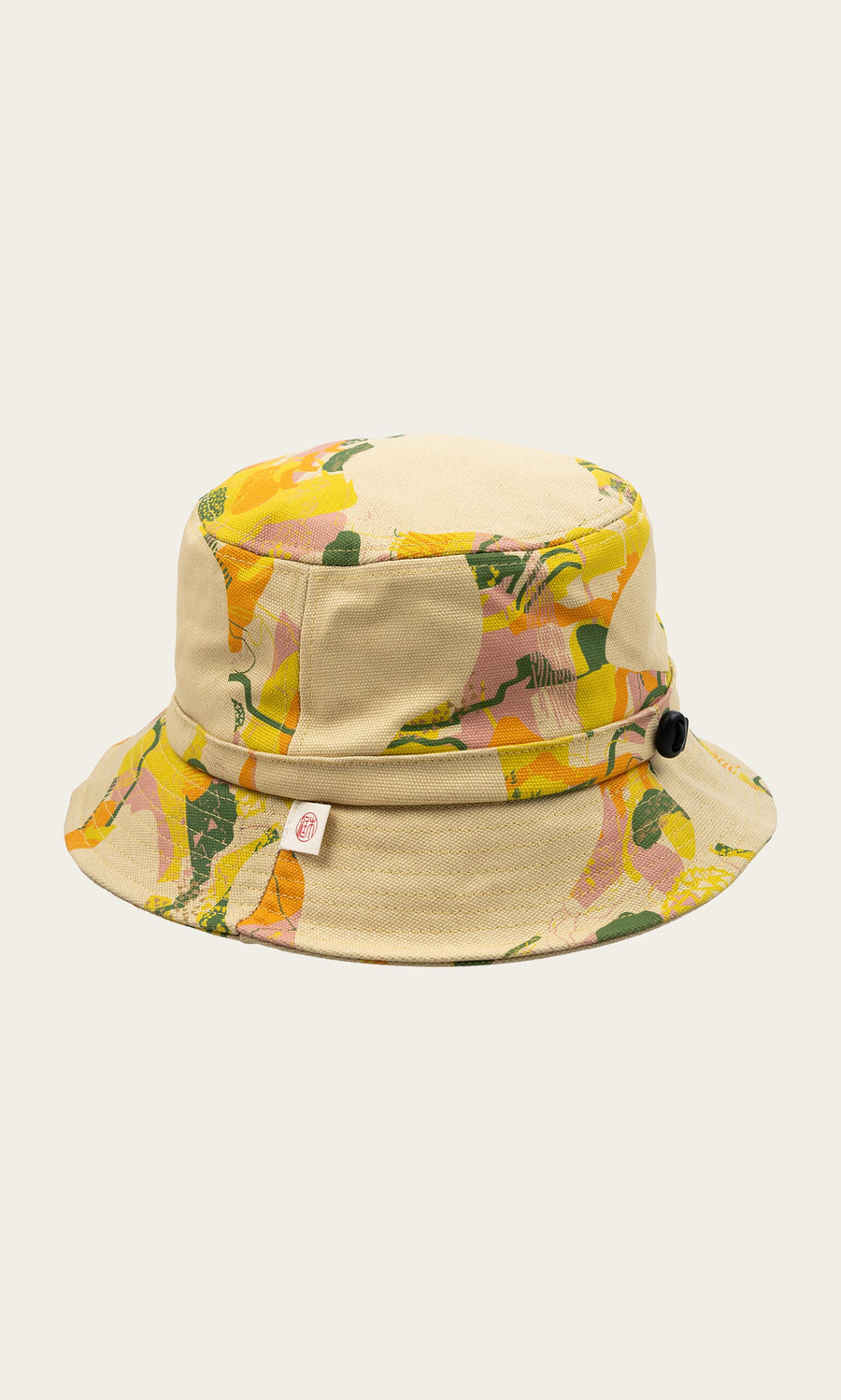 Plümo- Camo Bucket Hat in beige canvas features a colorful abstract floral design with yellow, orange, and green accents.