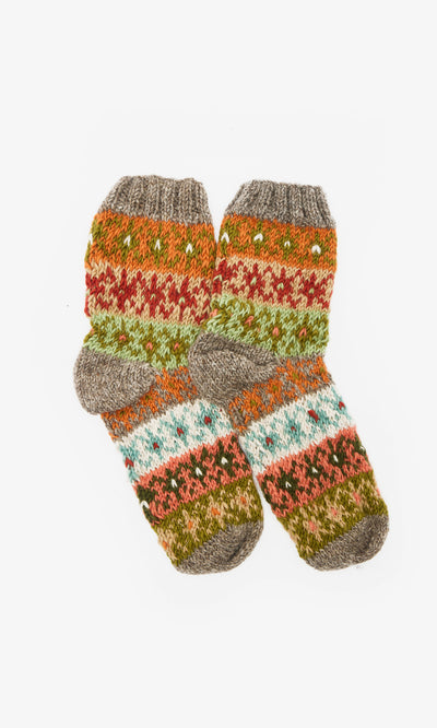 Plümo  Two colourful, hand-knitted wool Sofa Socks with orange, green, red, blue, and gray patterns on a white background.