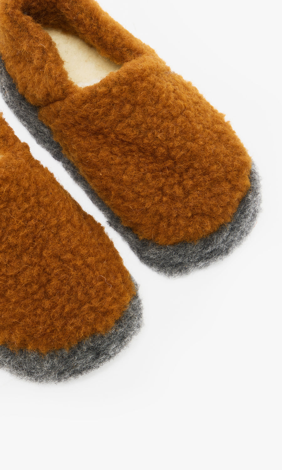 Plümo  Cozy Wool Slippers - Caramel, featuring fuzzy brown Irish wool and gray soles, partially shown on a white background.