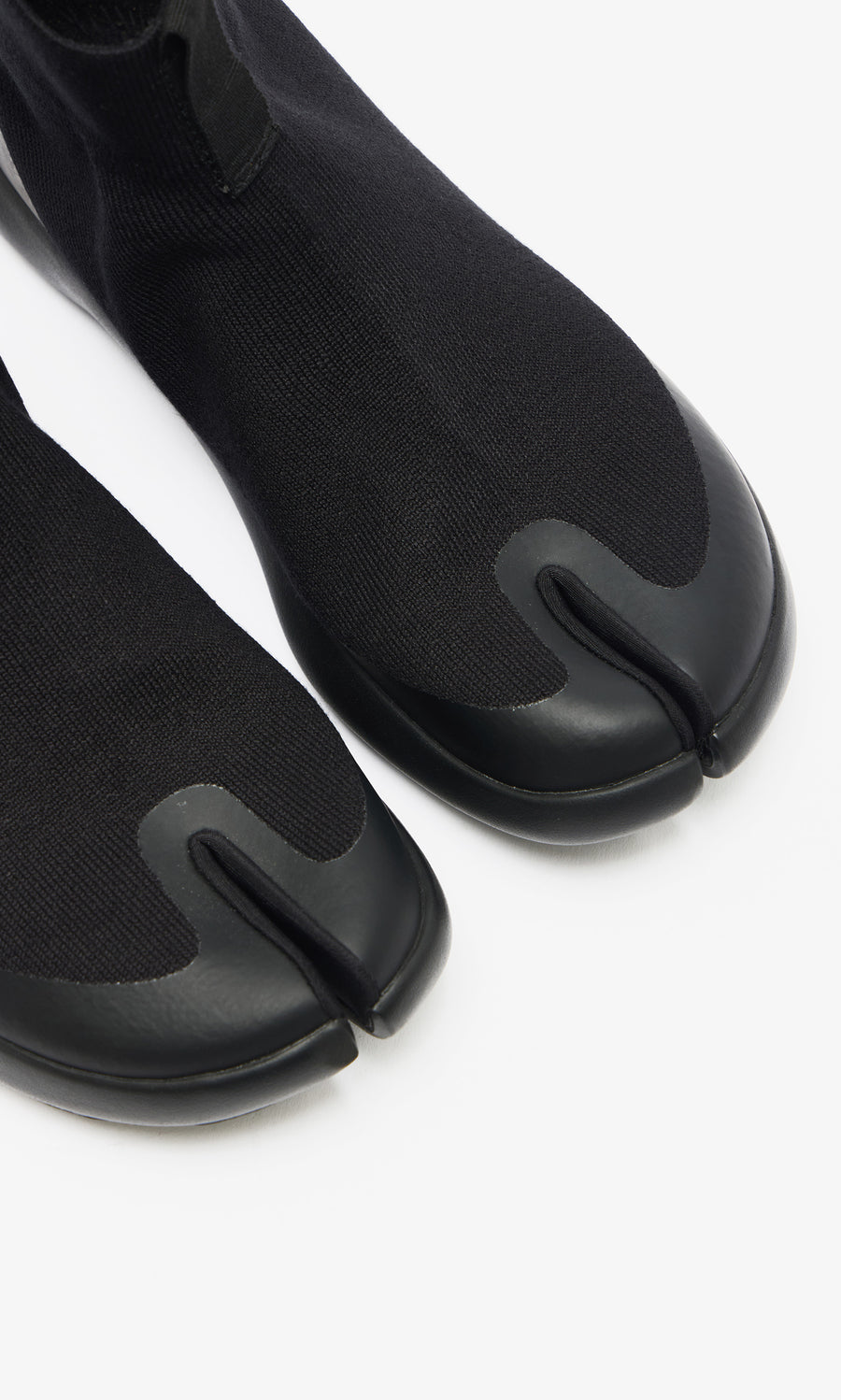 Plümo  Higher Tabi Boots in black feature a knit upper, rubber sole, and split-toe design, shown from above on white.