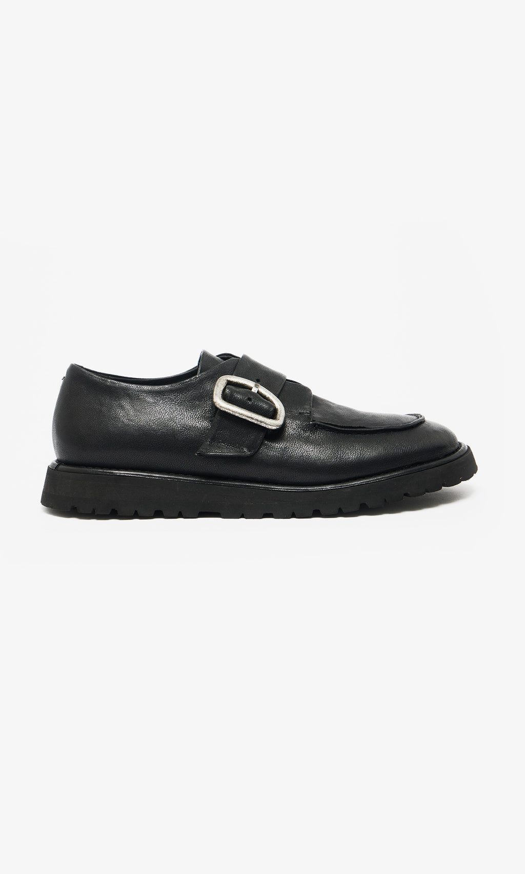 Plümo  Black Creepers feature black leather, a thick lugged rubber sole, and a large silver buckle on a white background.
