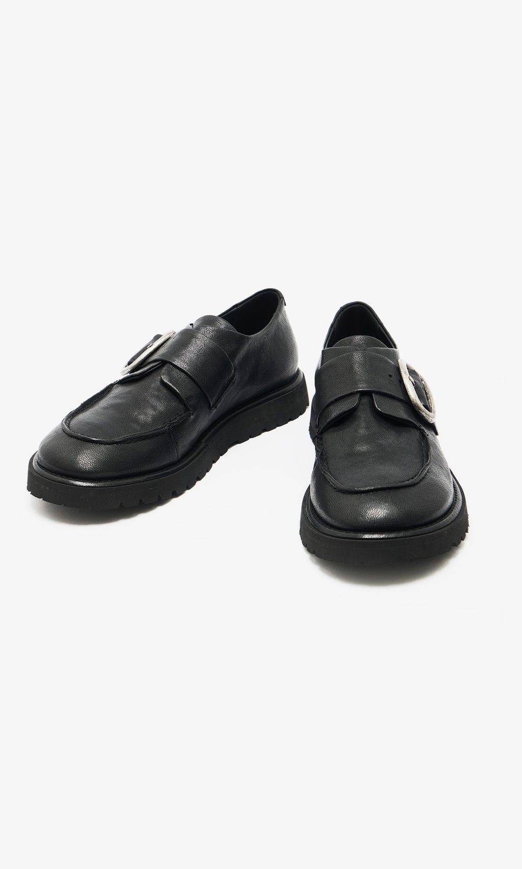 Plümo  A pair of black leather creepers with thick soles and a large silver buckle on each shoe.