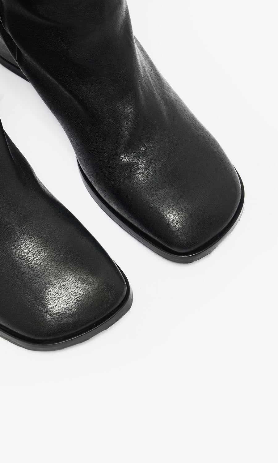Plümo  Close-up of Briony Boots—knee-high black leather with hidden internal wedge—on a white background.