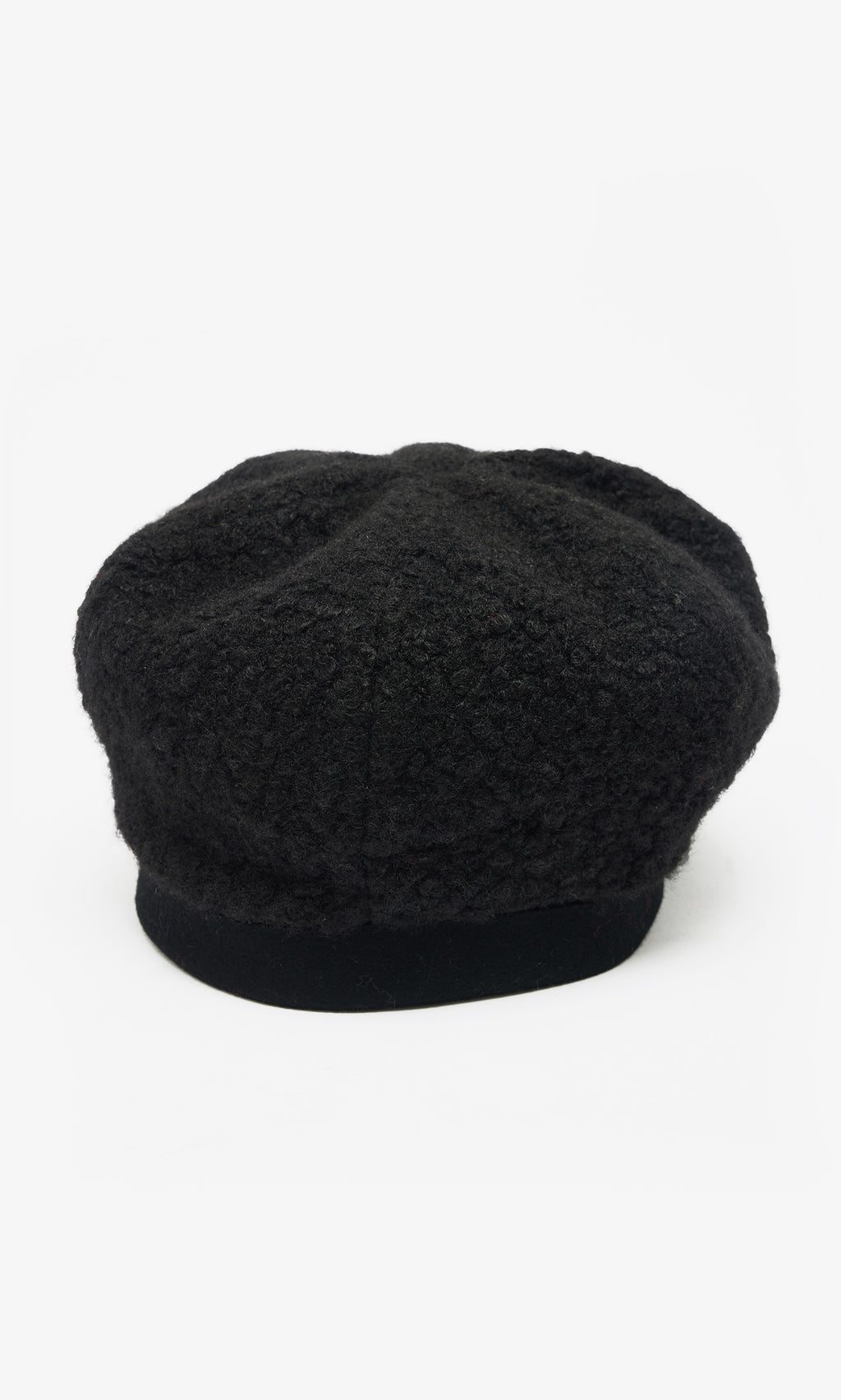 Plümo  The Perinne Beret: black boucle with a soft, rounded crown and flat brim, shown on white for adjustable fit.