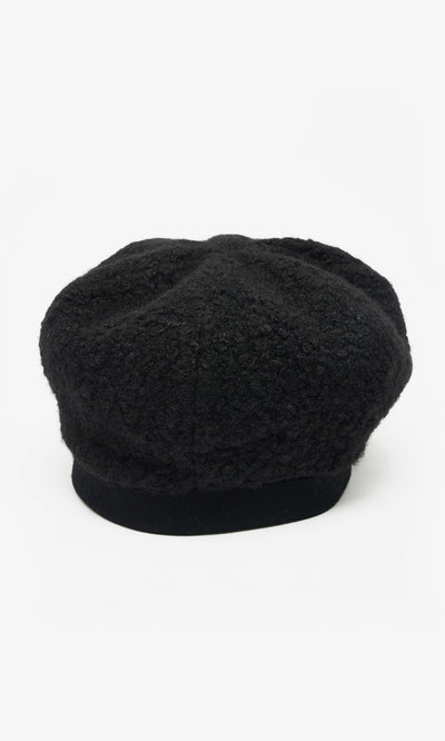 Plümo  The Perinne Beret: black boucle with a soft, rounded crown and flat brim, shown on white for adjustable fit.