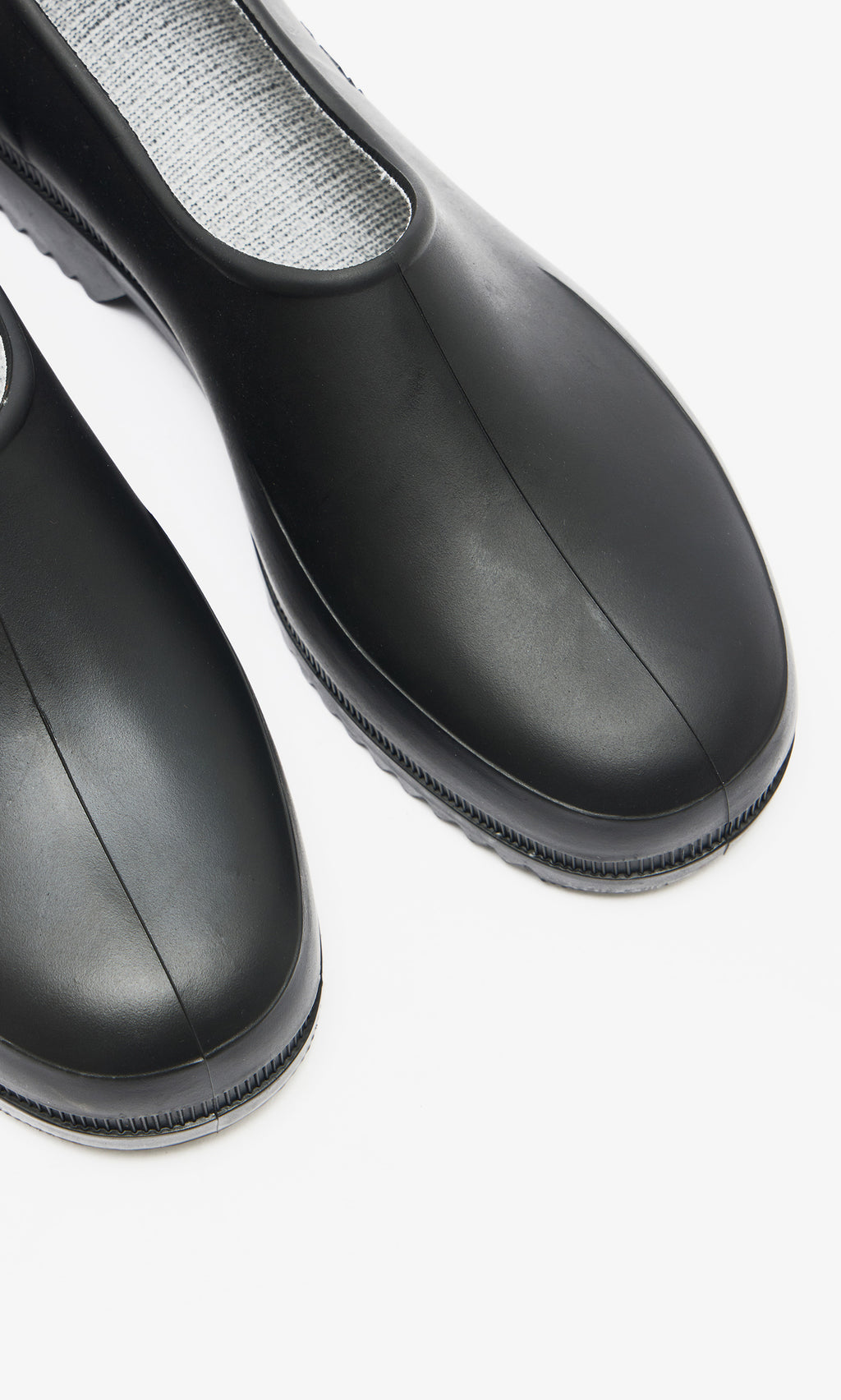 Plümo  Close-up of Gardenia Clogs - Black with a waterproof build and textured gray insole on a white background.