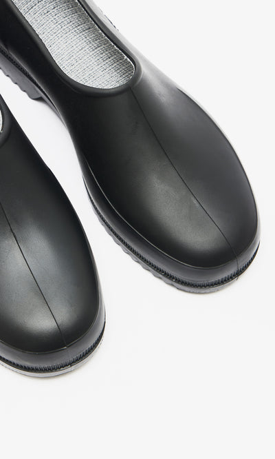 Plümo  Close-up of Gardenia Clogs - Black with a waterproof build and textured gray insole on a white background.