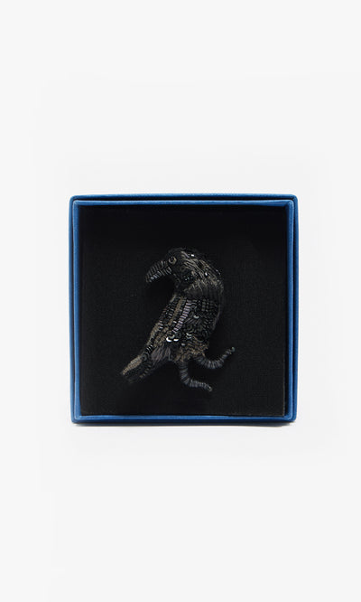 Plümo  The Black Raven Brooch is a handmade bird-shaped pin, elegantly presented in a blue box with a soft black interior.
