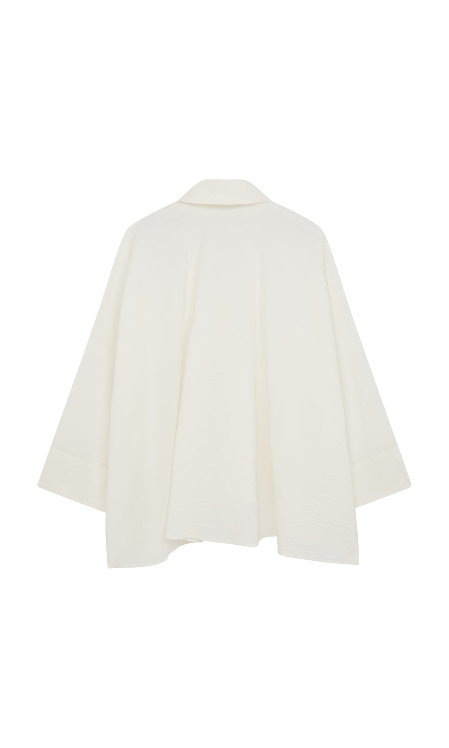 Plümo  Back view of the Laundered Shirt—a loose, textured cotton jacket with wide collar and flared hem, artist’s smock-inspired.