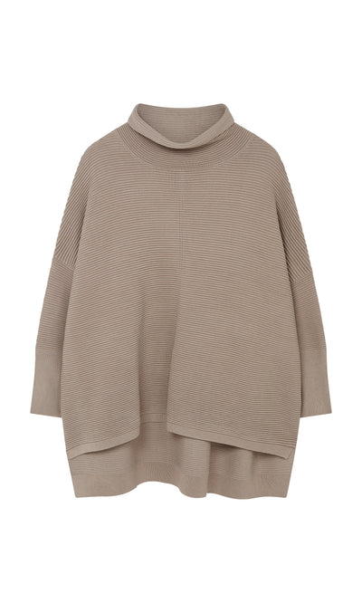 Plümo  Jack Rollneck - Miso: Beige ribbed knit poncho with wide sleeves, rollneck, and asymmetrical hem on a white background.