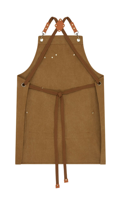 Plümo- Cobbler Apron in brown with faux leather straps, metal grommets, front pockets, and waist tie on white background.