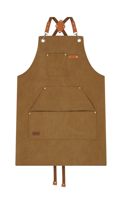 Plümo- Cobbler Apron in brown canvas with faux leather straps, front pockets, and metal grommets shown flat on white.
