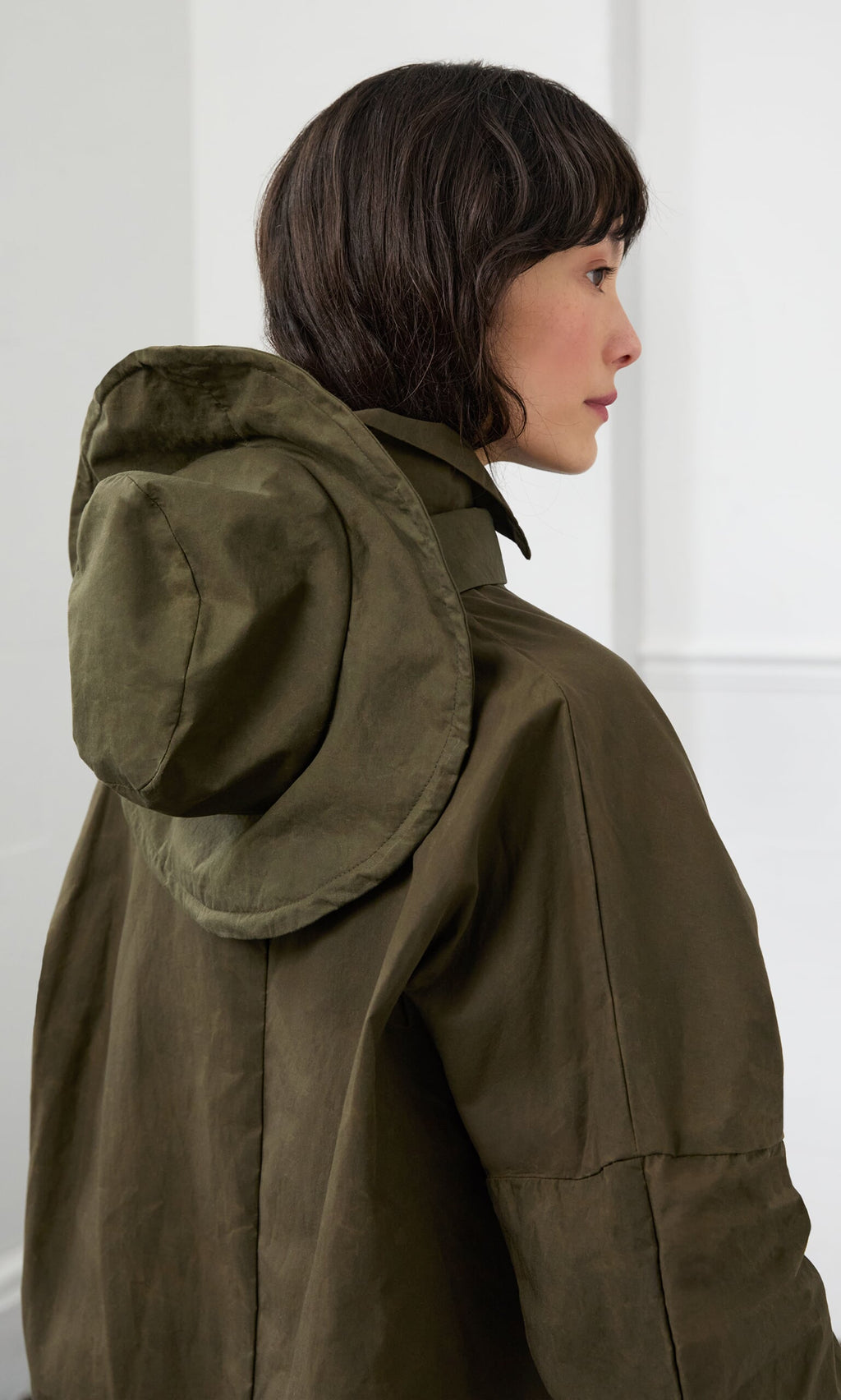 Plümo- Woman in profile wears a Gaucho Waxed Hat, standing in a bright indoor setting.