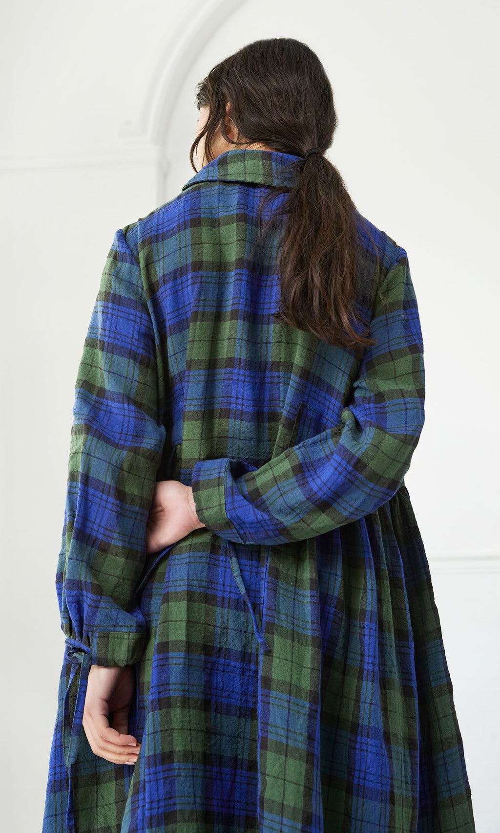 Plümo- Person with long brown hair in a low ponytail, seen from the back wearing the Laois Tartan Dress.