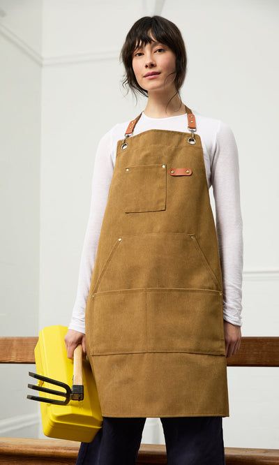 Plümo- A person in a brown apron holds the Yellow tool box, ideal for gardening tools, standing indoors against a plain background.