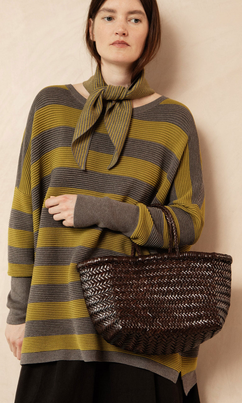 Plümo- Woman in the Jack Sweater - Butter Stripe by Plümo Studio, with a matching scarf and large woven brown handbag.
