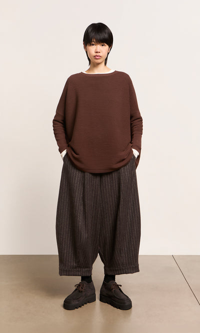 Plümo  Wearing the Jack Sweater - Bitter Chocolate from Plümo Studio, pinstriped pants, and black shoes.