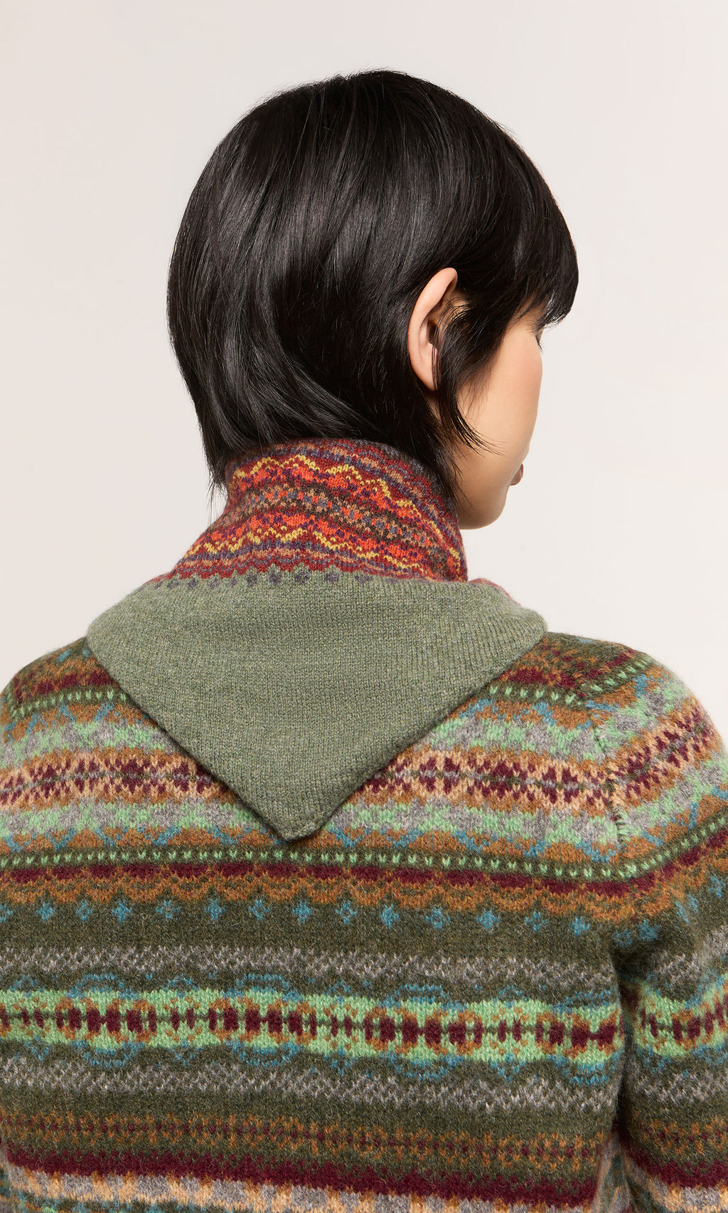 Plümo  Person with short black hair in the Lenie Necktie, shown from behind; inspired by Scottish Borders style.