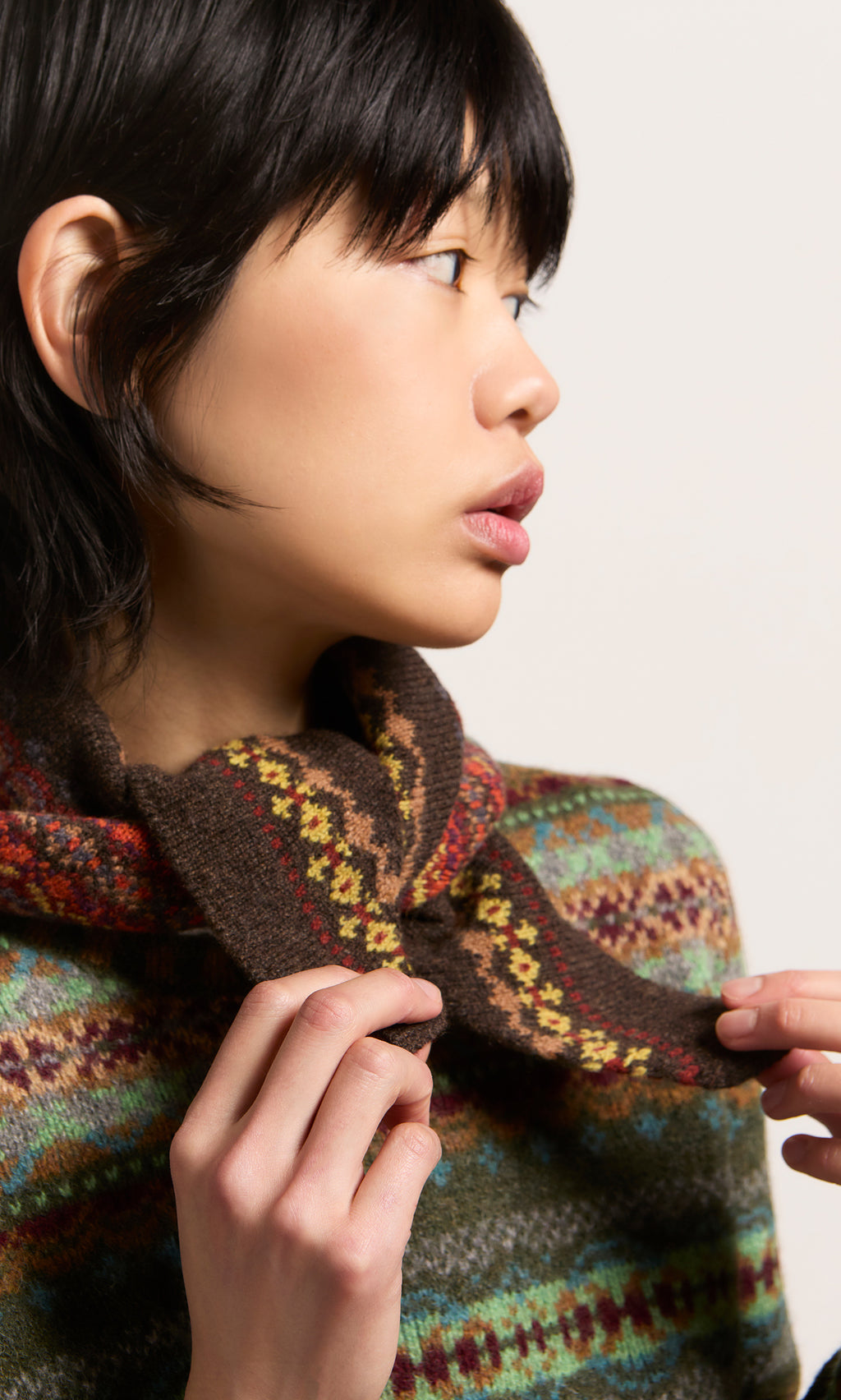 Plümo  Person in pure new wool Fairisle sweater, adjusting Lenie Necktie, inspired by Scottish Borders style.