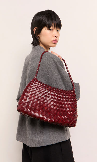 Plümo  Person in gray coat holding a Moone Bag over their shoulder, looking at the camera.