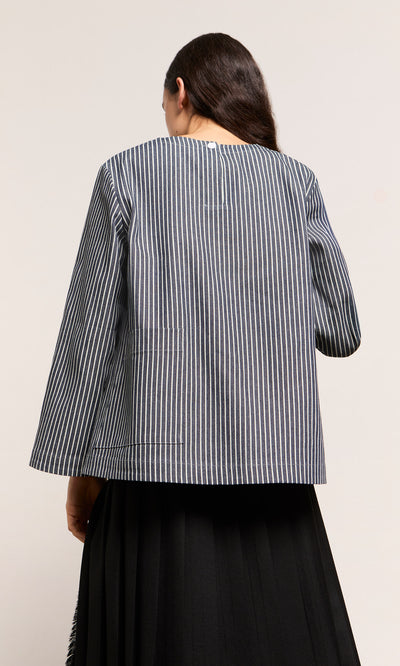 Plümo  A person with long dark hair is shown from the back wearing the black and white ticking stripe Norfolk Top.
