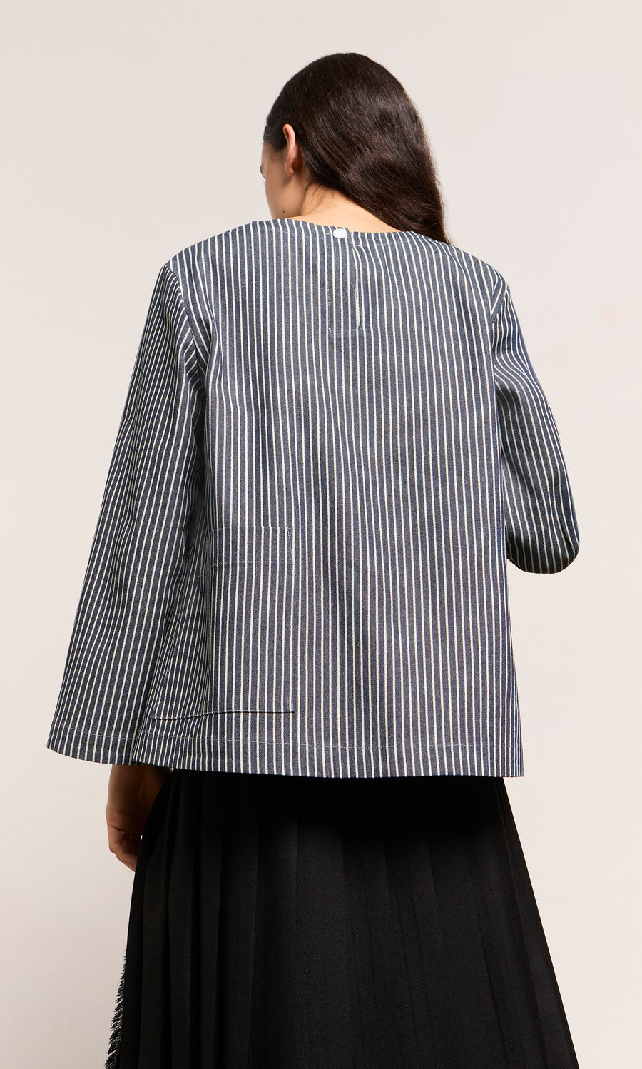 Plümo  A person with long dark hair is shown from the back wearing the black and white ticking stripe Norfolk Top.