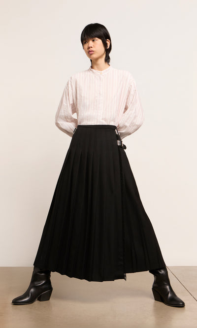 Plümo  Person in a striped white shirt, Storm Kilt maxi skirt, and black boots stands against a plain background.