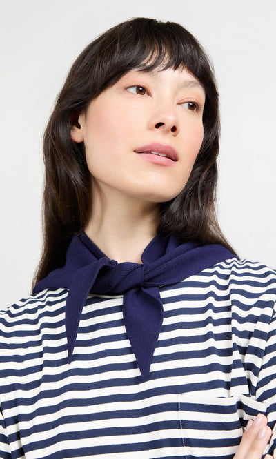 Plümo- Woman in a blue and white striped top with a Jona Necktie - Navy draped around her neck, looking slightly upward.
