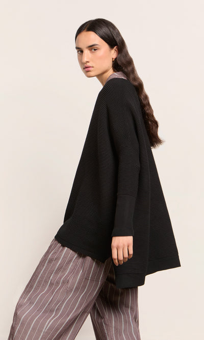 Plümo  Model with long dark hair wears the Jack Sweater - Black, styled oversized against a plain background.
