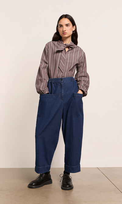 Plümo  Person in striped blouse, Polder Pants - Original Denim, and black shoes stands against a plain background.