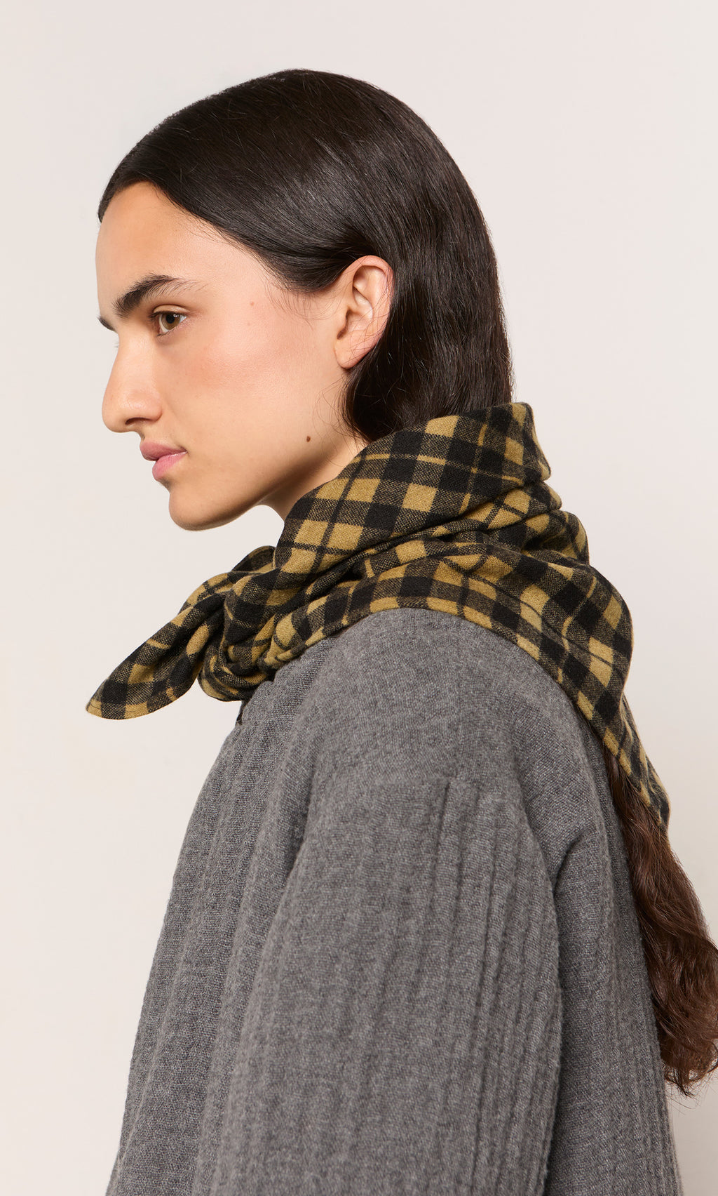 Plümo  Person in a gray sweater wears the Quadrant Necktie, shown side profile against a plain background.