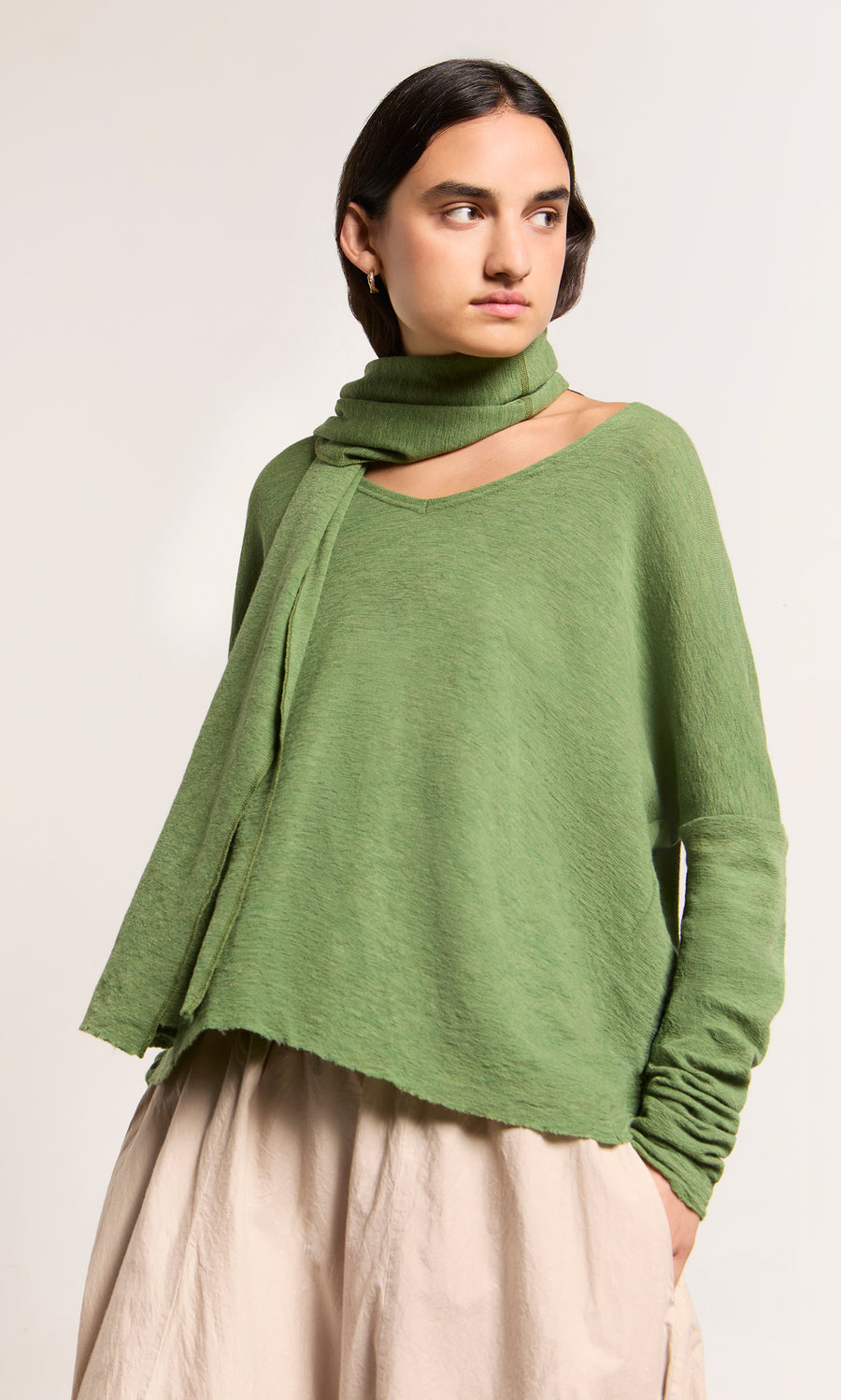 Plümo  Woman in Wisher Jumper, marled green, effortless Danish style against a plain backdrop.